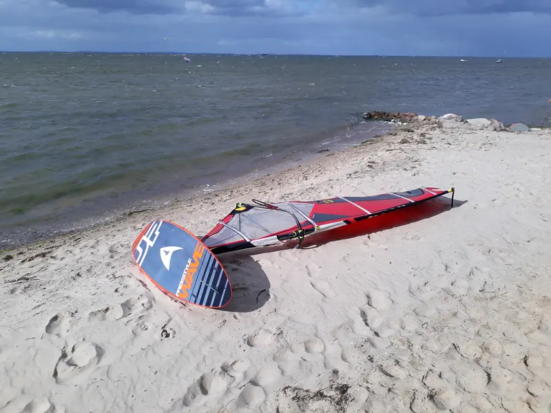 Windsurfboard und Segel am Strand vor Loissin